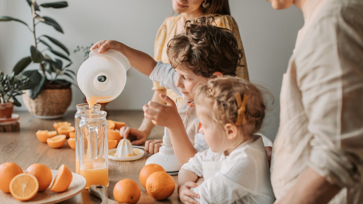 A family bonding over making fresh orange juice at home, enjoying quality time together.